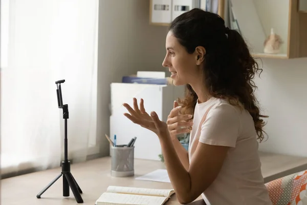 Vrouw zitten aan bureau kijken naar smartphone camera opnemen videovlog — Stockfoto