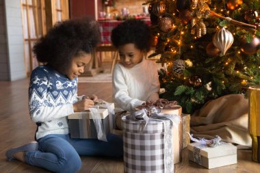 Coşkulu etnik çocuklar Noel hediyelerini birlikte açarlar.