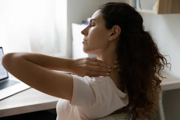 Žena dotek ztuhlý krk zažívá bolest z dlouhé sedavé práce — Stock fotografie