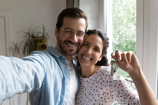 Feliz pareja webcam ver, esposa mostrando llaves de nueva casa —  Fotos de Stock