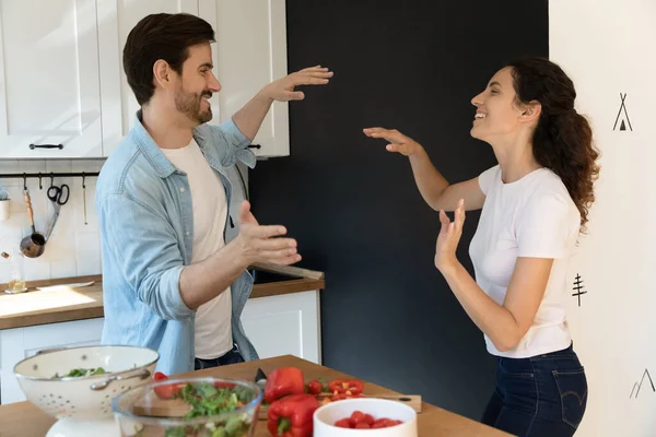 Cheery couple distracted from food preparation dancing in domestic kitchen — Stock Photo, Image