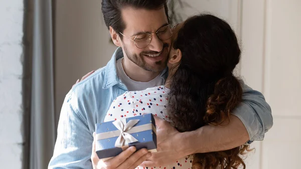 Glücklicher Ehemann umarmt Ehefrau fühlt sich dankbar für Geschenk-Box erhalten — Stockfoto