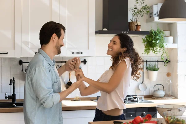 Coppia innamorata che si tiene per mano ballando in cucina a casa — Foto Stock