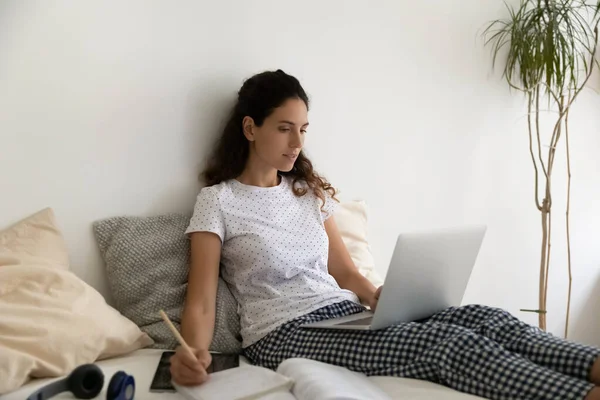 Vrouw gebruik laptop schrijft notities werken op afstand van huis — Stockfoto