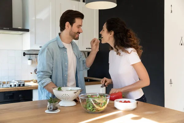 Vrouw eten van haar man handen vers blad van salade — Stockfoto