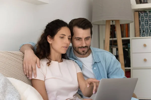 Millennial par sitta på soffan med bärbar dator köpa varor på nätet — Stockfoto