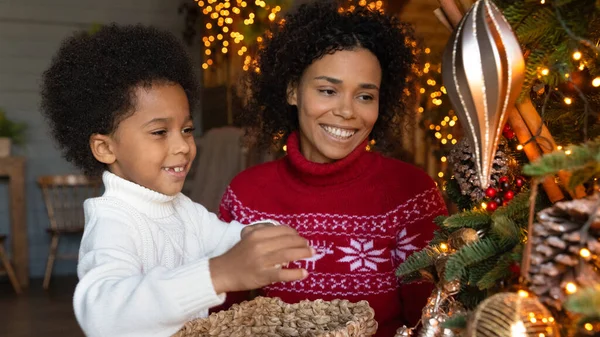 Smiling biracial mom and son decorate fir tree — Stock Photo, Image