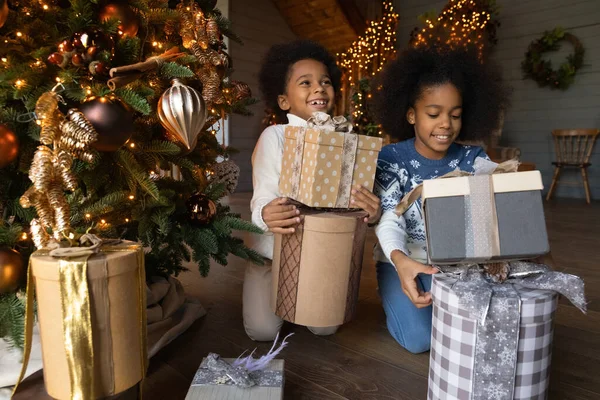 Szczęśliwy birasowe dzieci rozpakować prezenty na Boże Narodzenie — Zdjęcie stockowe