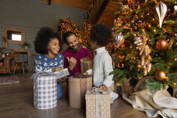 Feliz biracial pai e crianças desembalar Natal presentes juntos — Fotografia de Stock