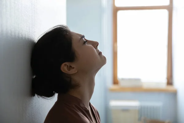 Stressé femme indienne avec les yeux fermés s'asseoir appuyé contre le mur — Photo