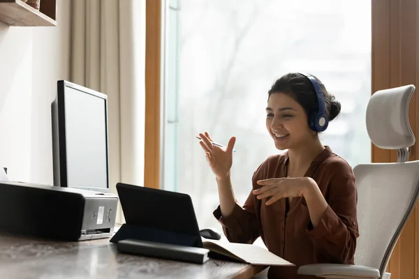 Young indian female in earphones provide virtual training using touchpad — Stock Photo, Image