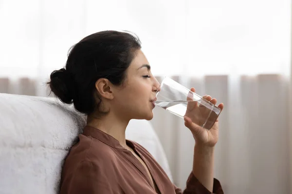 Young indian woman drink mineral water from glass at morning — Stock Photo, Image