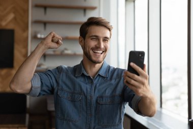 Heyecanlı beyaz adam zaferi akıllı telefondan lotoyu kazandı.