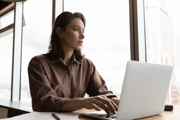 Pensive female employee work on computer make decision