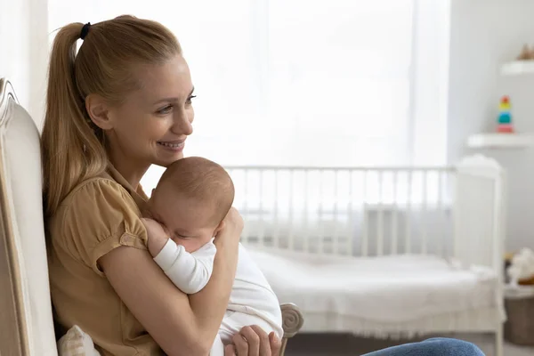 Happy young new mom holding sleepy baby in arms — Stock Photo, Image
