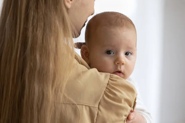 Porträtt av söt liten bebis vilar i glada mödrar armar — Stockfoto