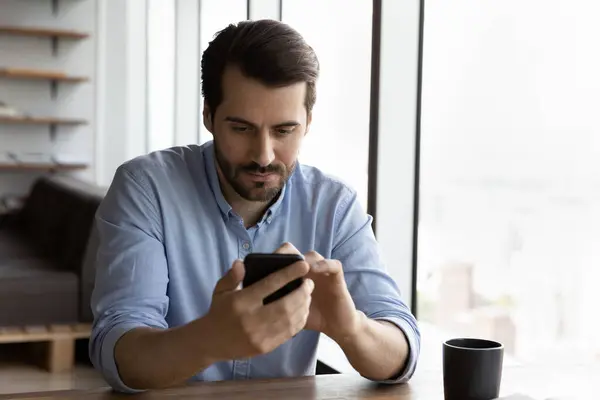 Hombre serio uso teléfono inteligente gadget mensajes de texto en línea — Foto de Stock