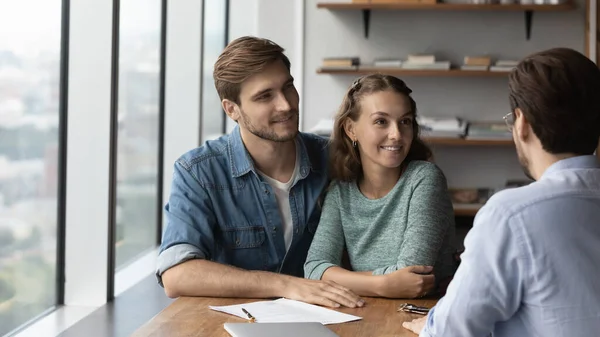 Gelukkige paar kopers praten met consultant op vergadering — Stockfoto