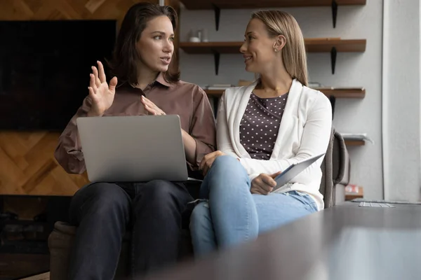Женщины-коллеги обсуждают бизнес-идеи с помощью ноутбука — стоковое фото