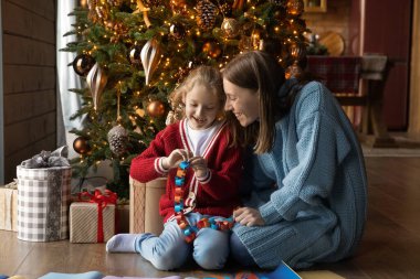 Mutlu sevimli kız annesiyle kağıt çelenk yapıyor..