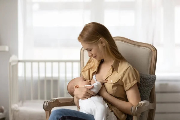 Happy new mother breastfeeding baby at home — Stock Photo, Image