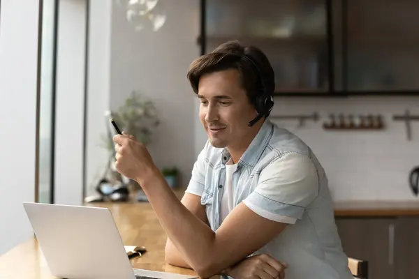 Young Caucasian man in headphones talk on webcam call — Stock Photo, Image
