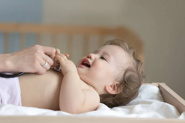 Feliz paciente de niño examinado por pediatra en el cambiador de bebés —  Fotos de Stock