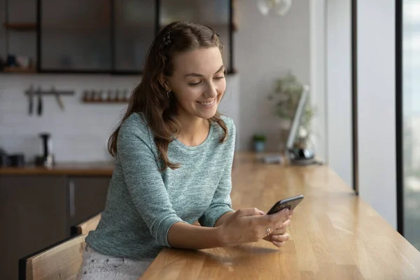 Leende kaukasiska kvinna använder mobiltelefon sms online — Stockfoto