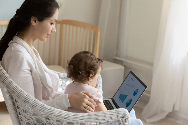 Ocupado nova mãe segurando laptop e bebê criança no colo — Fotografia de Stock