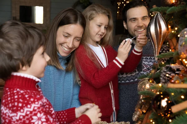 Happy milující rodina zapojená do zdobení x-mas slavnostní evergreen strom. — Stock fotografie