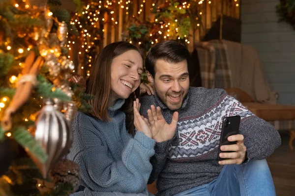 Emocional feliz jovem casal parabenizando com o Natal por videochamada. — Fotografia de Stock