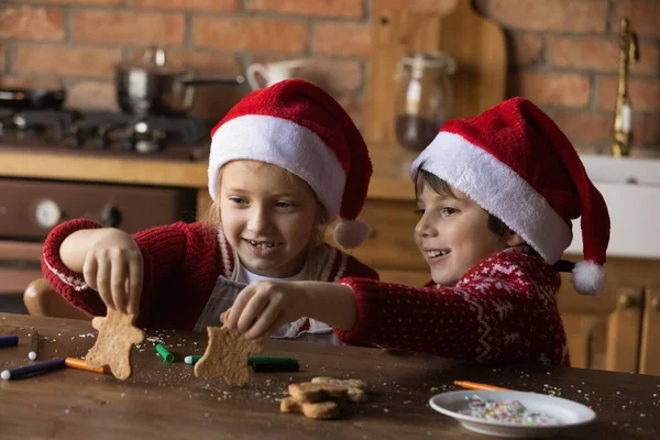 Feliz adorável crianças irmãozinhas brincando com pães de gengibre de Natal. — Fotografia de Stock