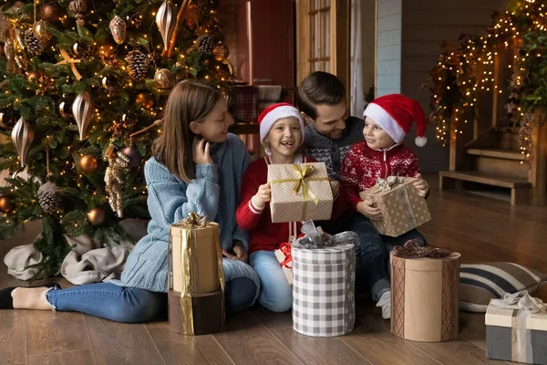 Emocjonalne małe dzieci czują się podekscytowane rozpakowywaniem prezentów z rodzicami. — Zdjęcie stockowe