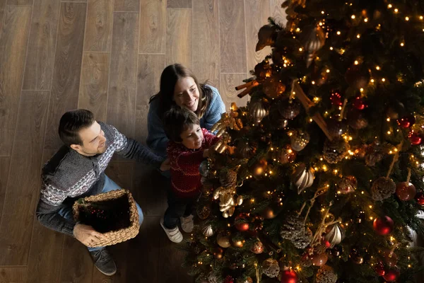 Alegre família festiva decoração árvore de Natal em casa. — Fotografia de Stock