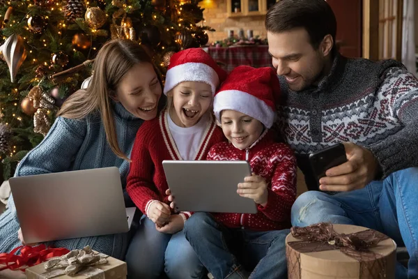 Overhappy familie paar met kinderen kijken grappige kerst cartoons. — Stockfoto