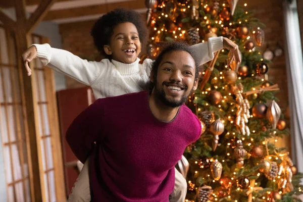 Overjoyed ethnic dad and son play near fir tree — Stock Photo, Image