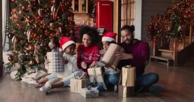 Neşeli, sevgi dolu, Afro-Amerikan ailesi hediyelerini birlikte açıyor..