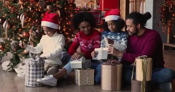 Χαμογελώντας ειλικρινείς μικτή οικογένεια αγώνα ανοίγοντας κουτιά με δώρα Χριστουγέννων. — Αρχείο Βίντεο