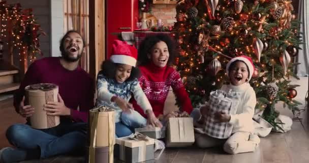 Χαρούμενη μικτή οικογένεια αγώνα αισθάνεται ενθουσιασμένος για να πάρει χριστουγεννιάτικα δώρα. — Αρχείο Βίντεο