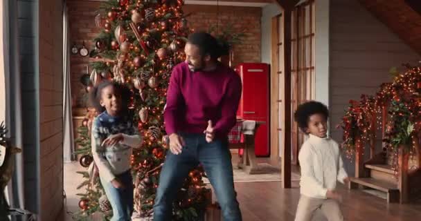 Ειλικρινής ενεργό biracial οικογένεια χορό γιορτάζει τις χειμερινές διακοπές στο σπίτι. — Αρχείο Βίντεο