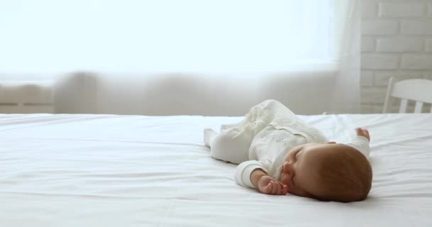 Lugnt nyfött barn sover ensam på sängen — Stockvideo