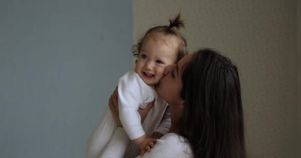 La mère aimante lève les bras et embrasse sa petite fille — Video