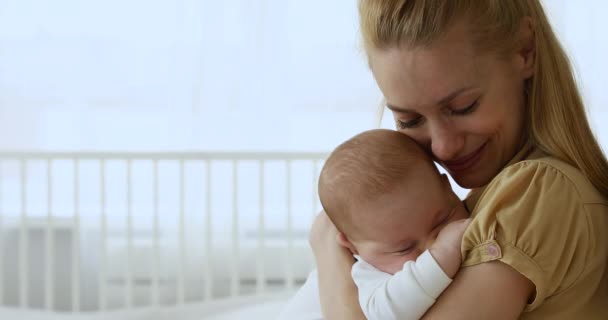 Junge schöne Mutter kuschelt ihr süßes schlafendes Baby — Stockvideo