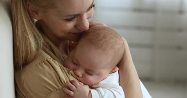 Прекрасна дитина заснула в обіймах матері, крупним планом — стокове відео