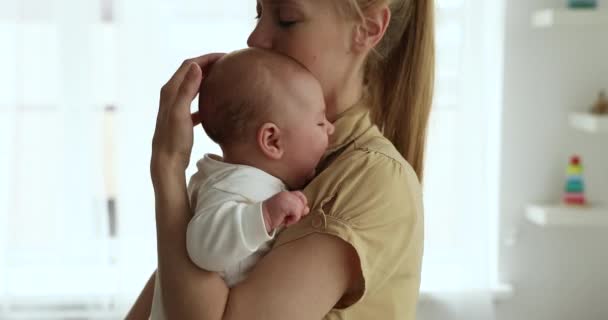 Amante mãe segurando bebê nos braços beijando e acalma-lo — Vídeo de Stock