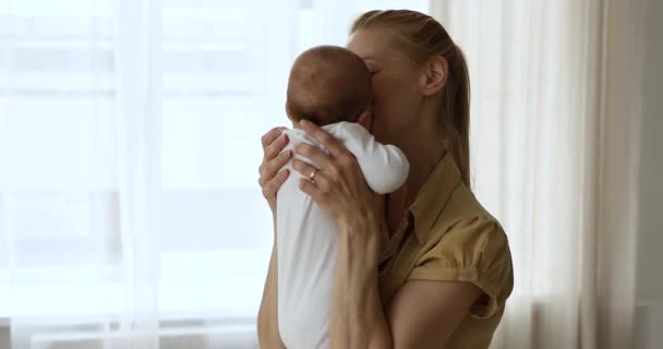 Mother kissing newborn and put in crib for daytime nap — Stock Video