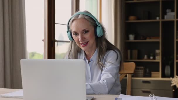 Mujer mayor usar auriculares uso portátil consulta plomo a través de videocall — Vídeos de Stock