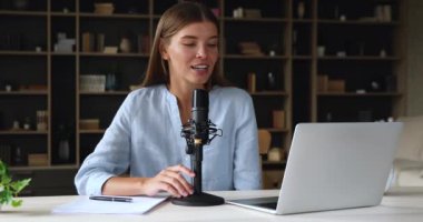 Genç bayan dizüstü bilgisayardan önce oturup mikrofon kayıt podcast 'ine konuş