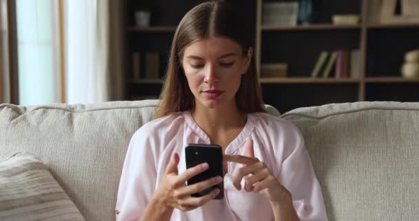 Desapontado gen z aplicativo de bate-papo de navegação feminina no telefone — Vídeo de Stock