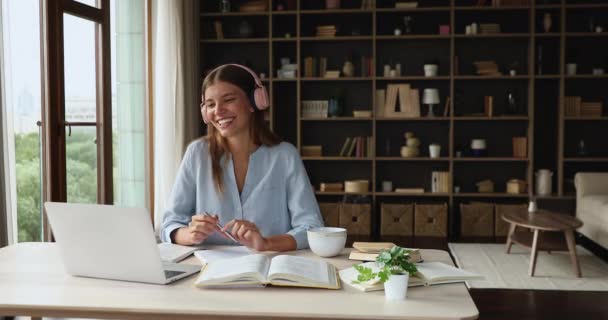 Studentka ve sluchátkách se radí s učitelkou na virtuálním workshopu — Stock video